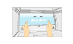 양손으로 덮개의 아래 부분을 잡고 위로 들면서 앞쪽으로 빼내는 이미지