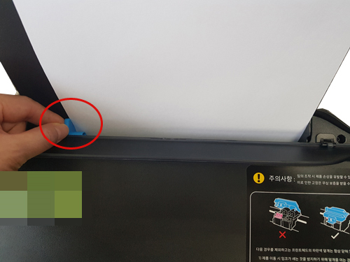 용지를 넣은 후 옆의 파란색 조절 가이드를 움직이는 예시 화면