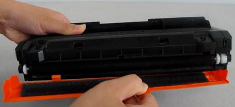 토너의 드럼 보호하는 주황색 캡을 잡고 제거하는 화면