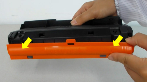 토너의 드럼 보호하는 주황색 캡을 잡고 제거하는 화면