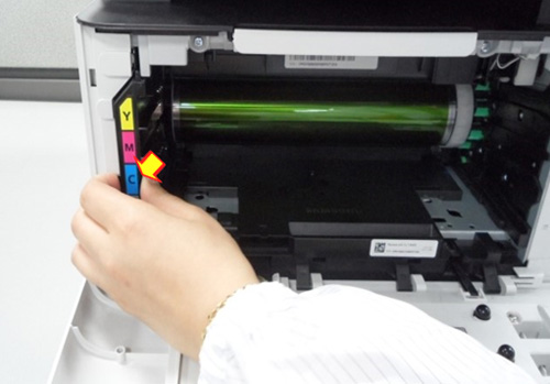 왼쪽 옆면의 폐토너통을 앞으로 잡아당겨 꺼내는 화면