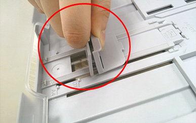 용지 길이 가이드를 손으로 누르는 화면