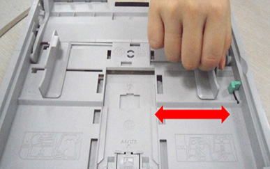 용지 너비 가이드를 눌러 잡고 이동시키는 화면